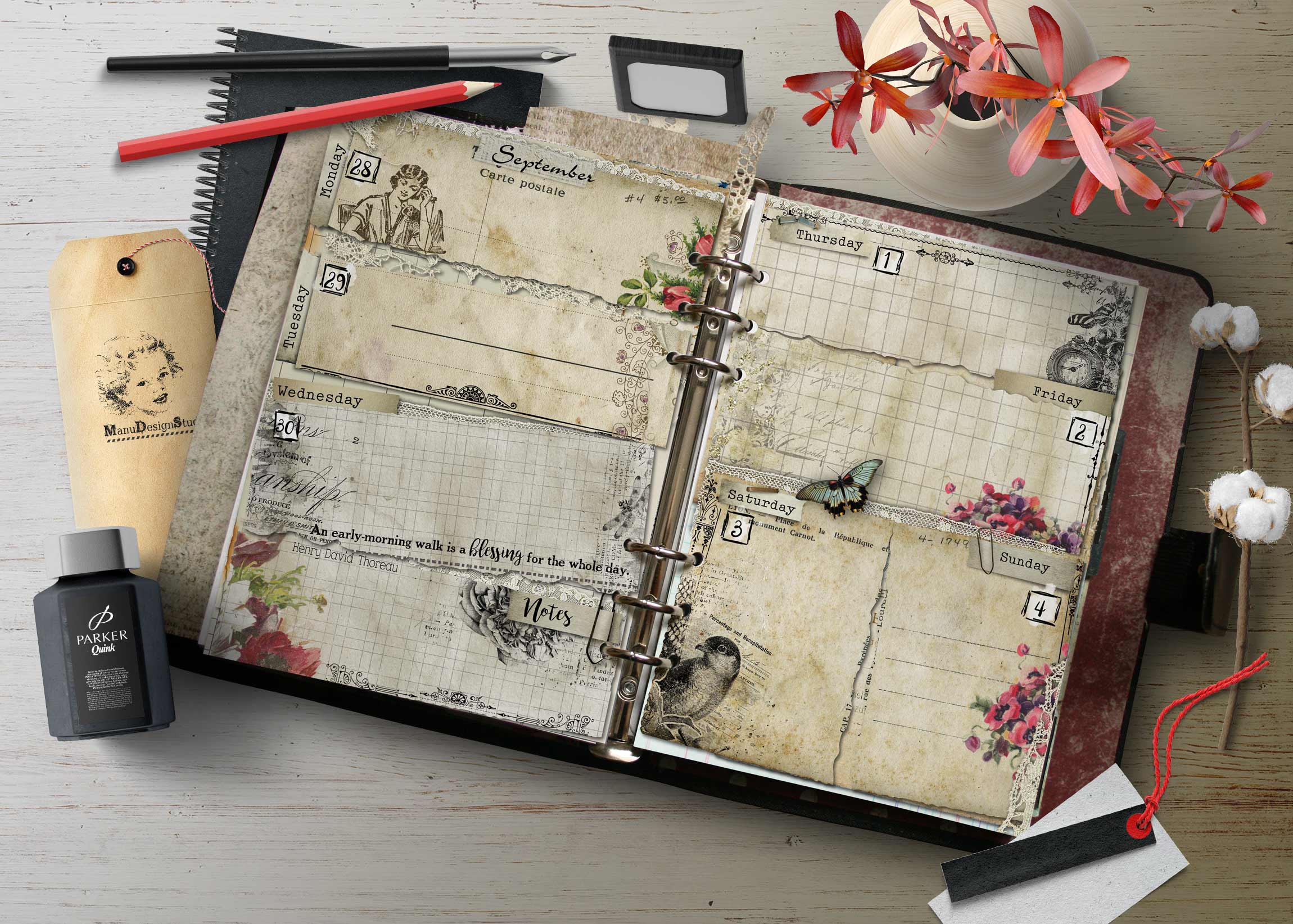 Open vintage planner with decorative floral pages and writing tools on a worn wooden desk