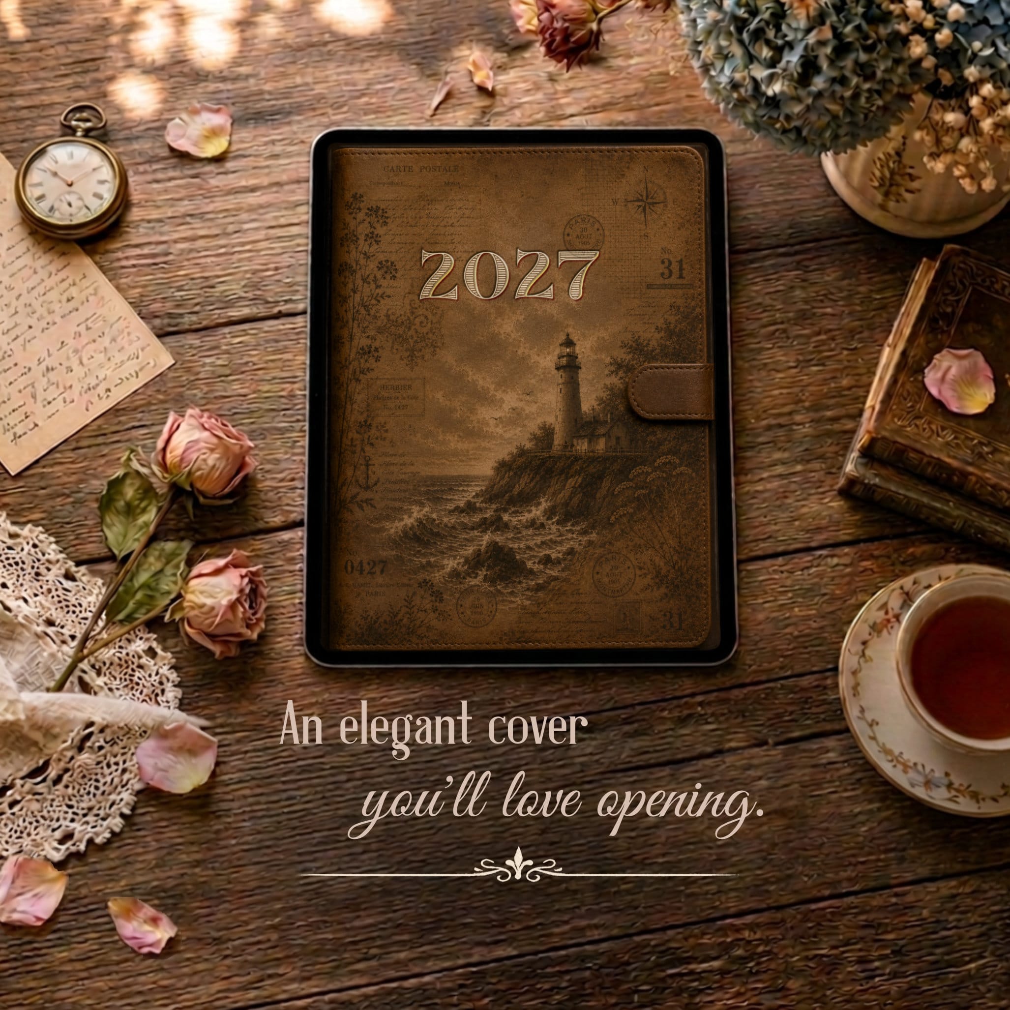 Brown vintage-style planner cover for a digital planner for GoodNotes showing 2027, placed on a wooden table with dried roses, lace, and a pocket watch nearby.
